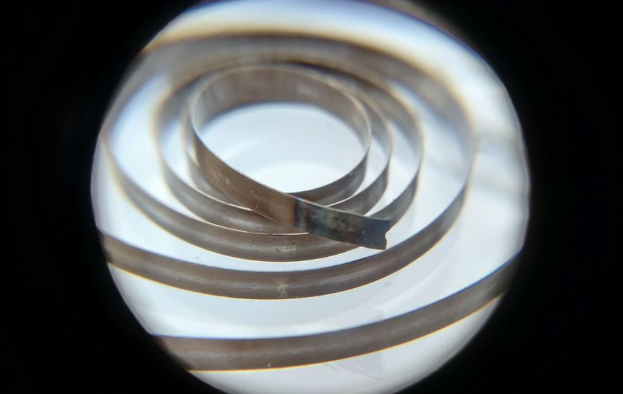Broken mainspring end being annealed over a flame to soften it