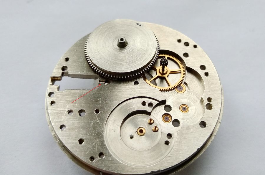 Barrel and intermediate wheel placed on the plate, with an arrow marking the half-tunnel for the clutch