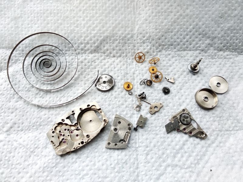 Cleaned watch parts showing restored finish